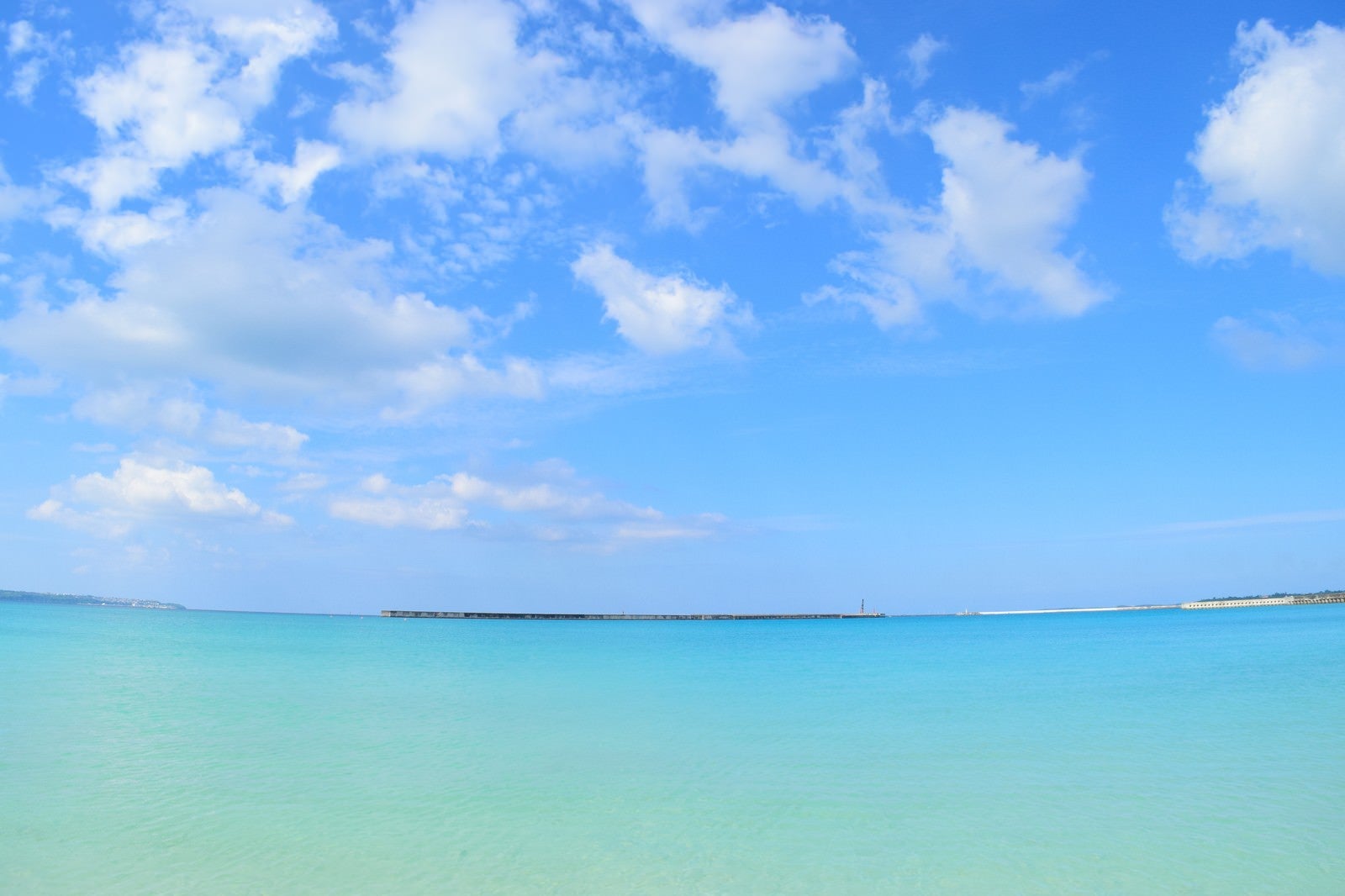 「沖縄の海と遠くに見える防波堤」の写真