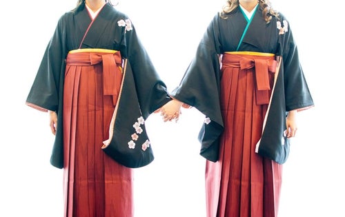 手を繋いで卒業を迎える袴姿の女子の写真