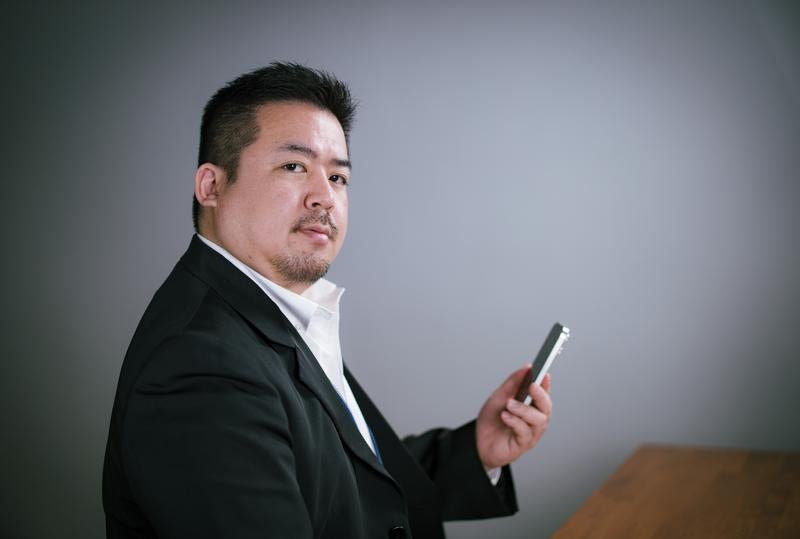 デスクサイドでスマホを操作してキリッの写真