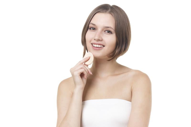 スキンケアルーティンでパフを使い顔に当てる女性モデル