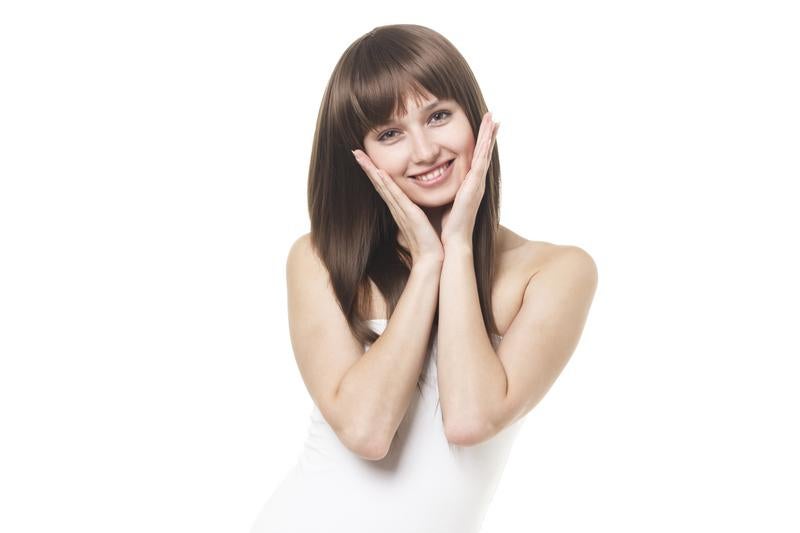 両手で頬を包んで微笑む女性