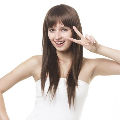 ピースサインで笑顔のロングヘア女性の写真