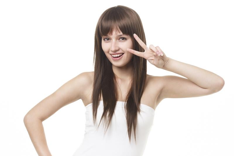ピースサインで笑顔のロングヘア女性
