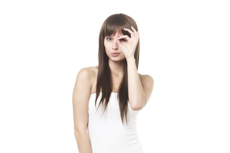 OKサインを目元にかざす女性