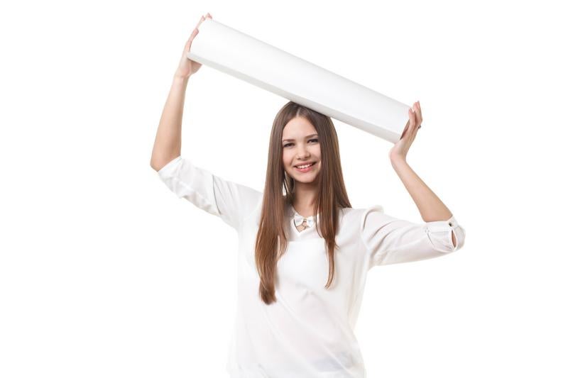 白いロール紙を頭上に掲げてポーズを取る長髪の女性の写真