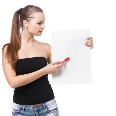 黒いベアトップ姿で白いパネルに文字を書く女性の写真