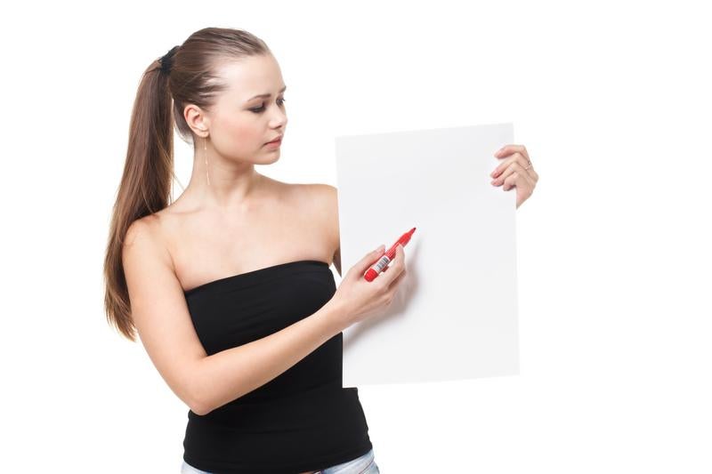 赤いペンで白いパネルに書く女性モデルの写真