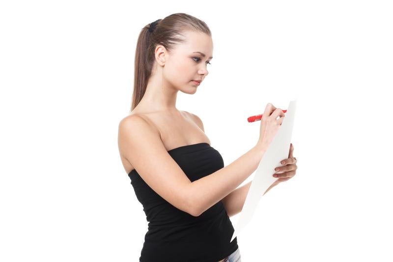 白い用紙にペンで書き込みをする女性の写真