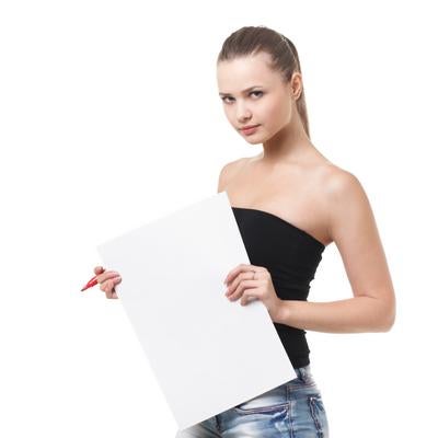 白い紙を持ちポーズをとるベアトップ姿の女性モデルの写真