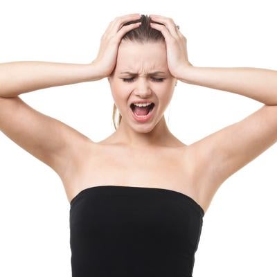 頭を抱えて叫ぶ女性モデルの写真