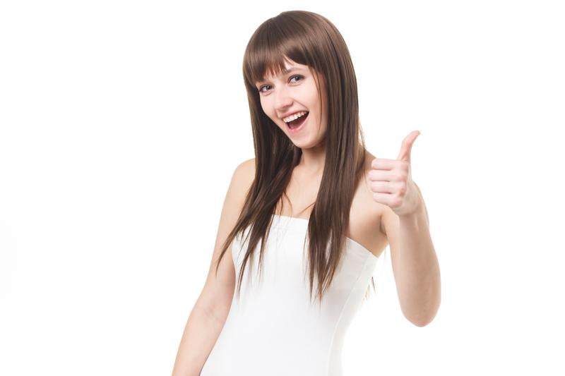親指を立てたグッジョブポーズで笑顔を見せるロングヘアの女性モデルの写真