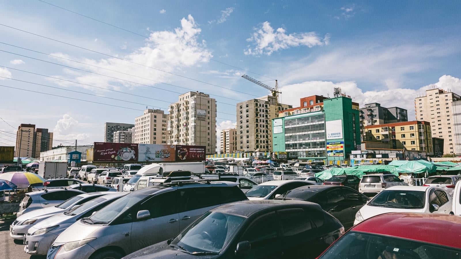 「車で埋め尽くされたナラントール市場の駐車場の様子」の写真