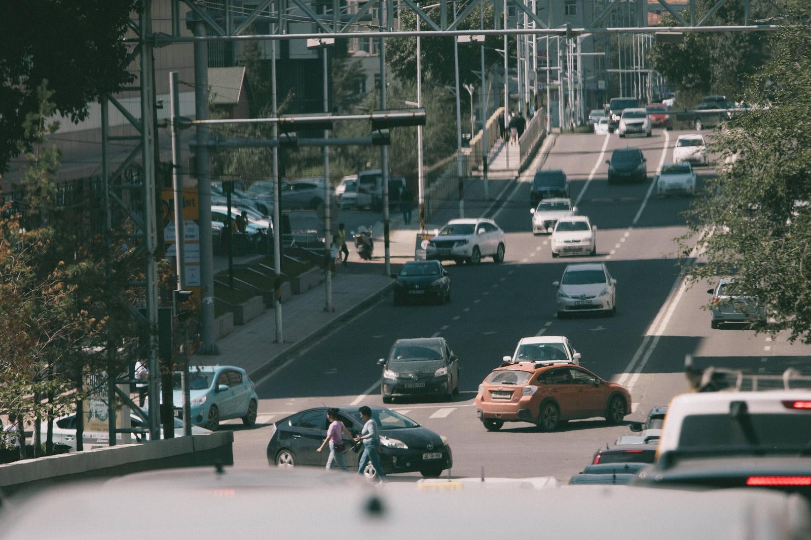 「ウランバートルの主要道路を走る車、だいたい砂埃で汚れている」の写真