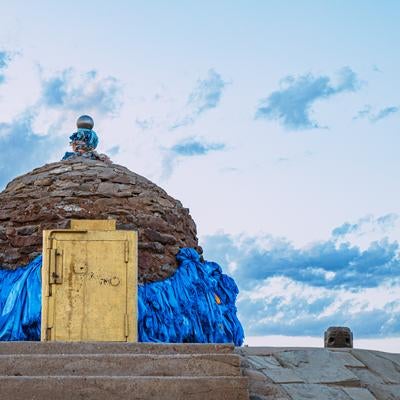 ▲石造りの塔を背にカメラを構える旅人の写真