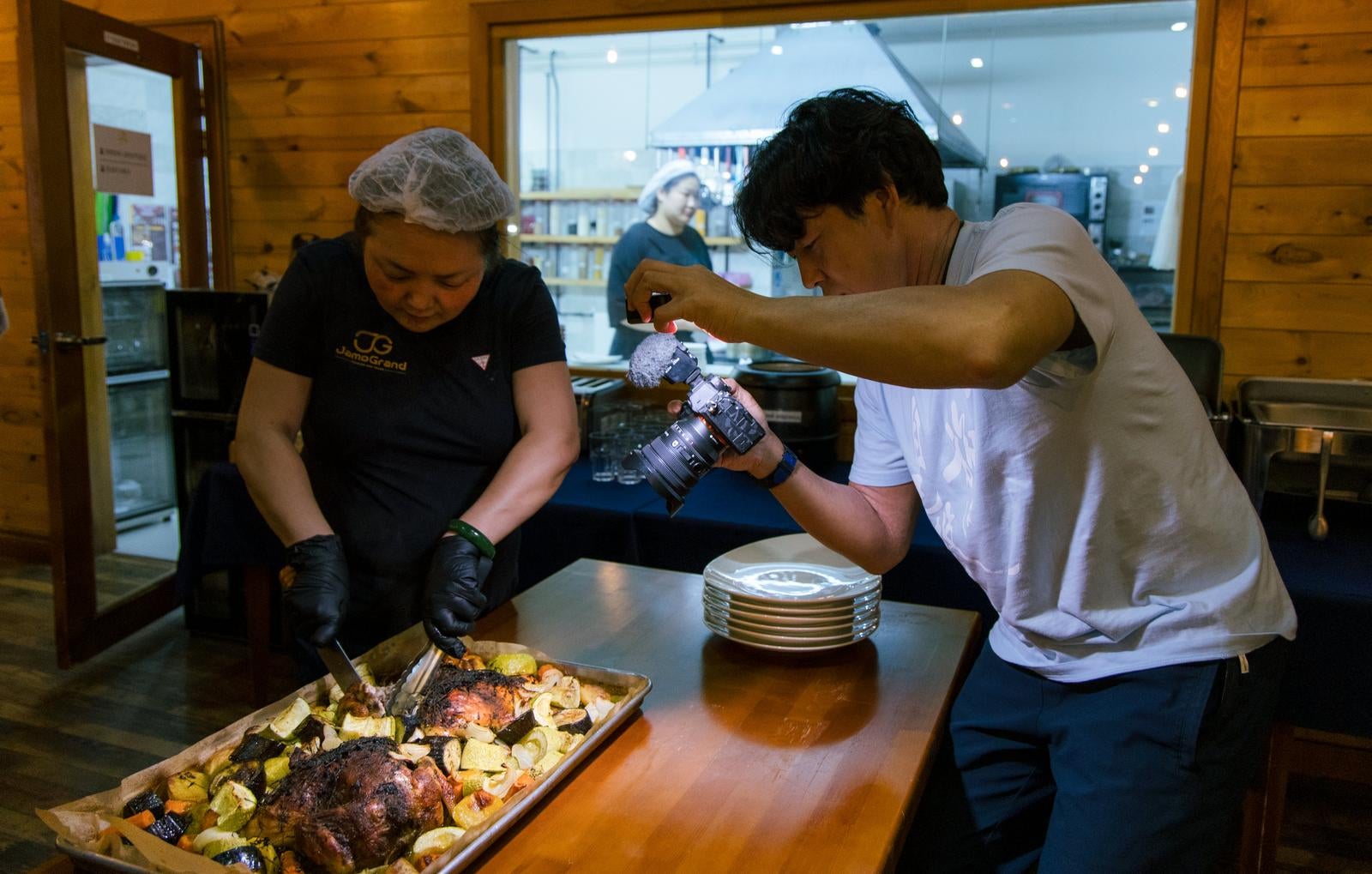 「調理している様子を撮影する旅行系Youtuber」の写真［モデル：もーりー］