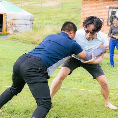 元モンゴル相撲の選手と対戦するもーりーさんの写真