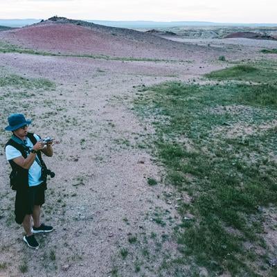 サインシャンドの草原と砂漠の間でドローンを操縦するトラベラーの男性の写真