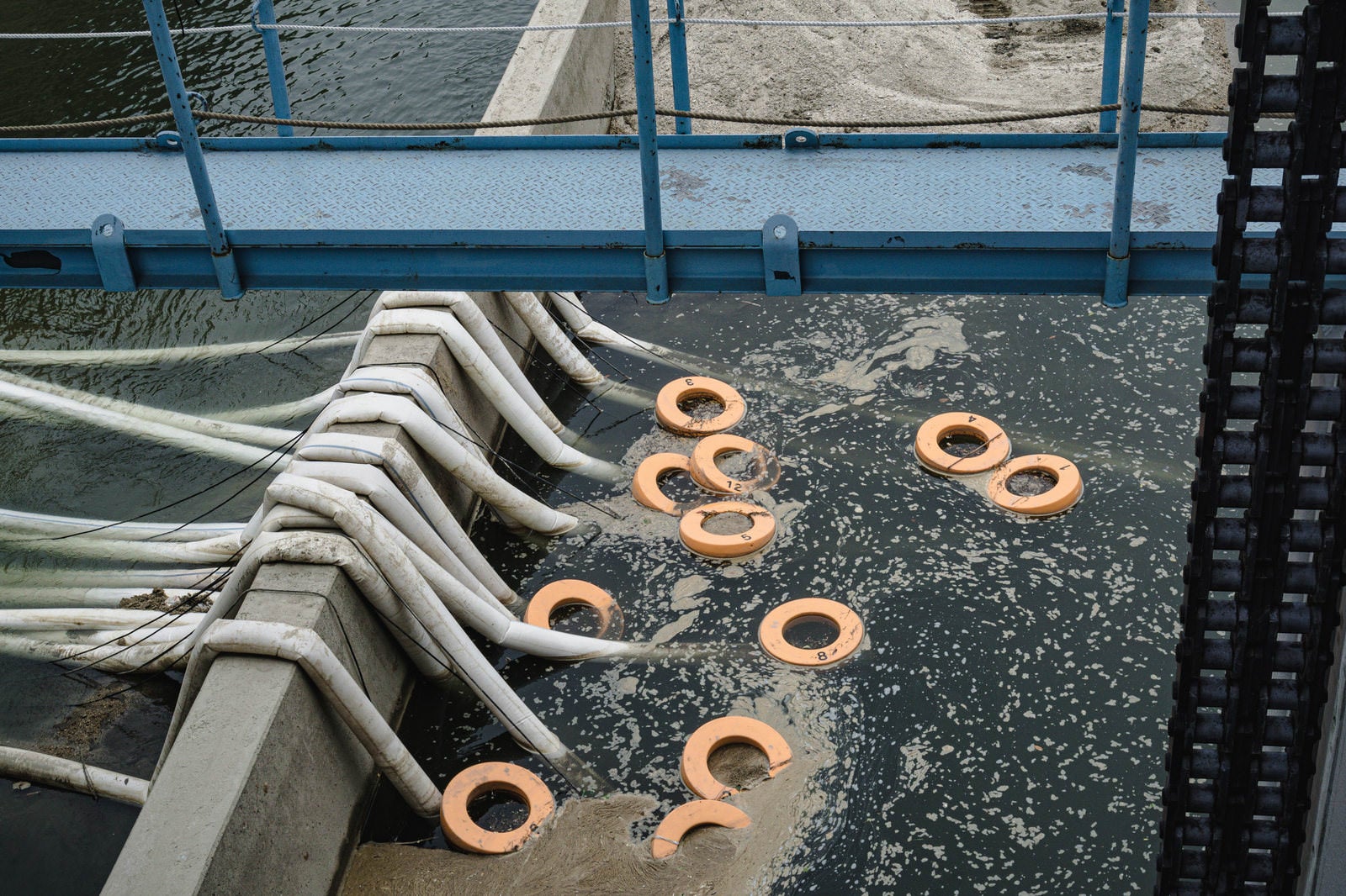 「頭首工天端から見える排水ホースと排水ポンプの目印の浮き輪」の写真