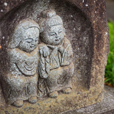 寄り添う姿の「双体道祖神」の石像の写真