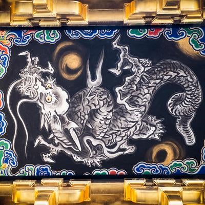 金色の装飾枠に囲まれた黒地に描かれた「鳴き龍」の彫刻装飾の写真