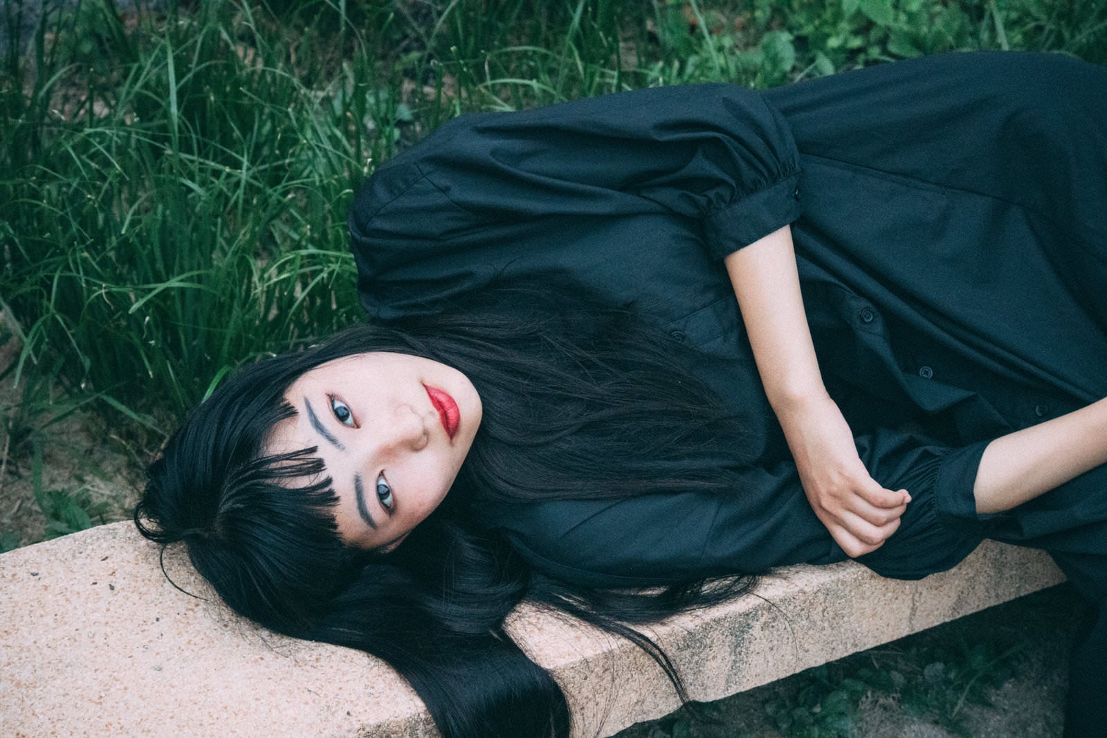 「ベンチに寝転ぶ黒ワンピ女子」の写真［モデル：なんこ］