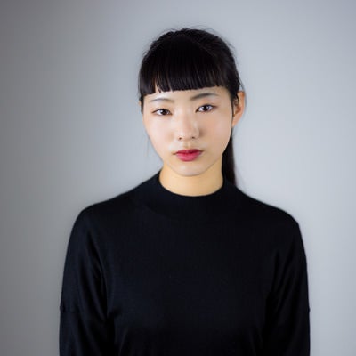 オン眉で真顔のポージングをする女性のポートレートの写真