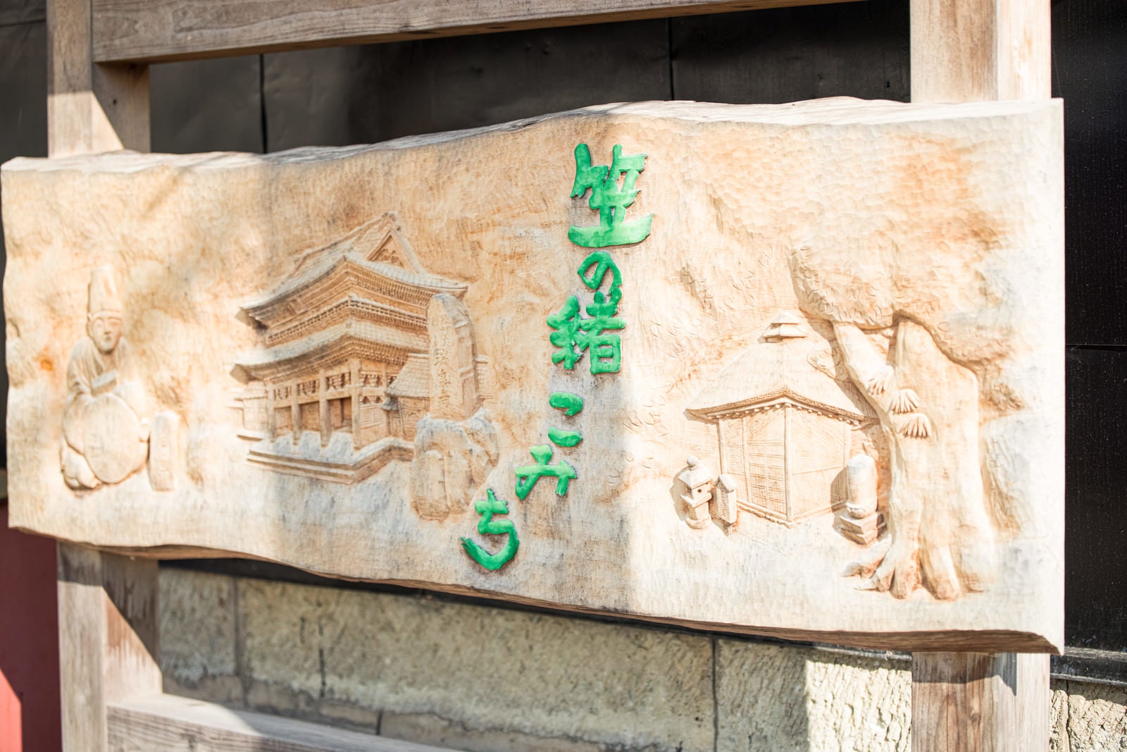 「「笠の緒こみち」と彫刻された木彫り看板（富山県南砺市）」の写真