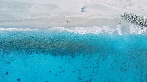 砂浜の足跡と美しい神津島の海（多幸湾）の写真