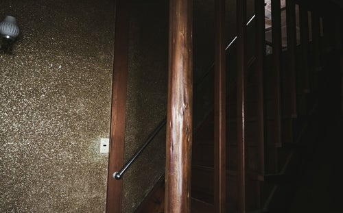 ２階に上がる木造の階段の写真