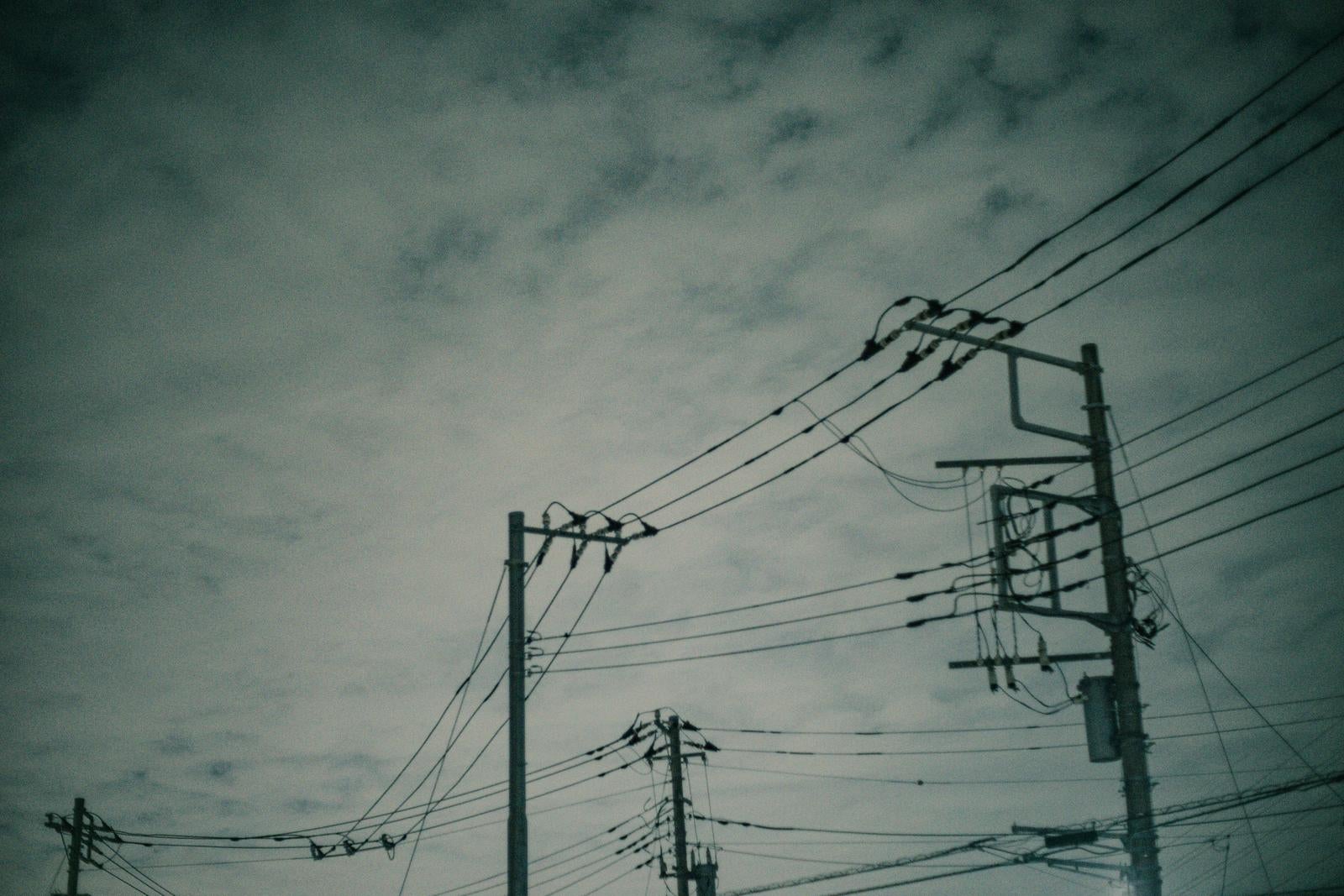 「雲行き怪しい電柱と電線」の写真