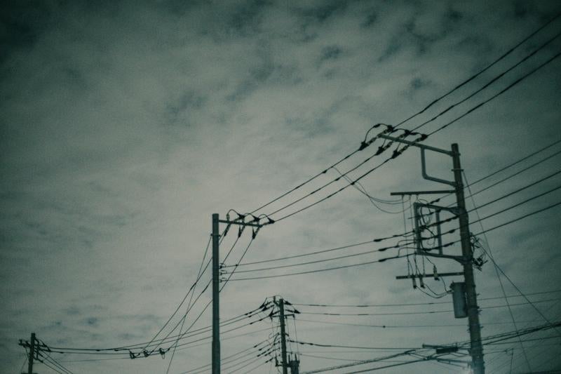 雲行き怪しい電柱と電線の写真