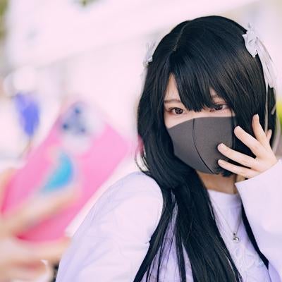 スマートフォンを構えた自撮りするマスク女子の写真