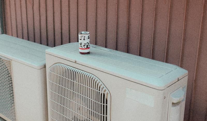 室外機の上に置かれたメッセージ缶の写真