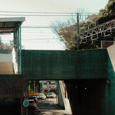 コンクリートの壁が囲む無機質な都市の日常の写真