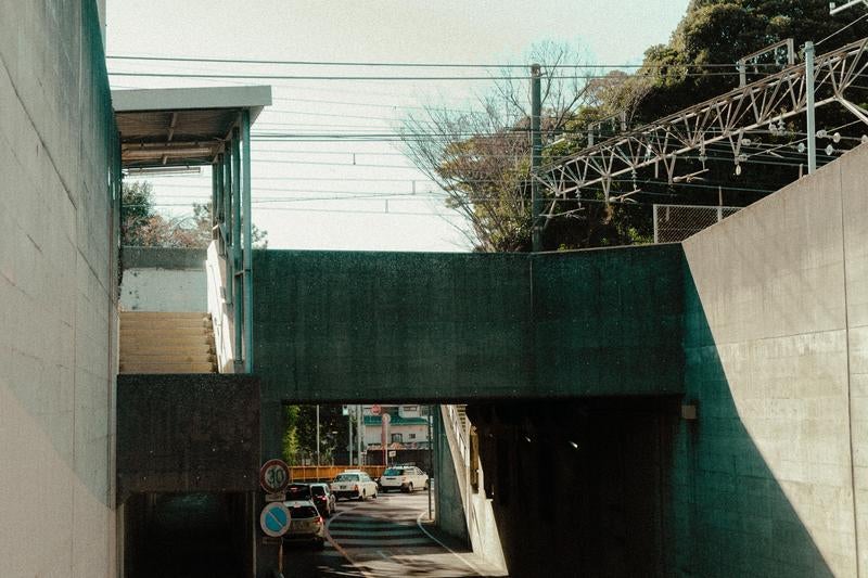 コンクリートの壁が囲む無機質な都市の日常の写真
