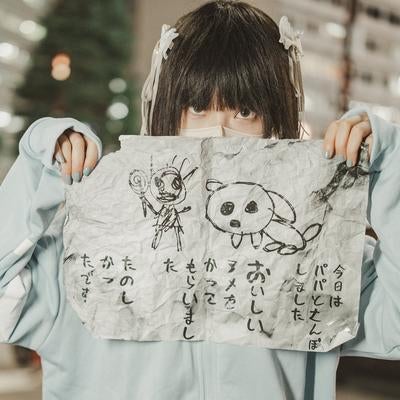 水色パーカーを着た黒髪の女の子が怪文書を掲げる姿の写真