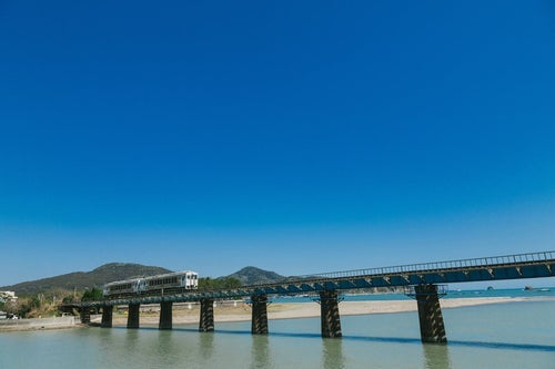 鉄橋を渡る観光列車「海幸山幸」の写真
