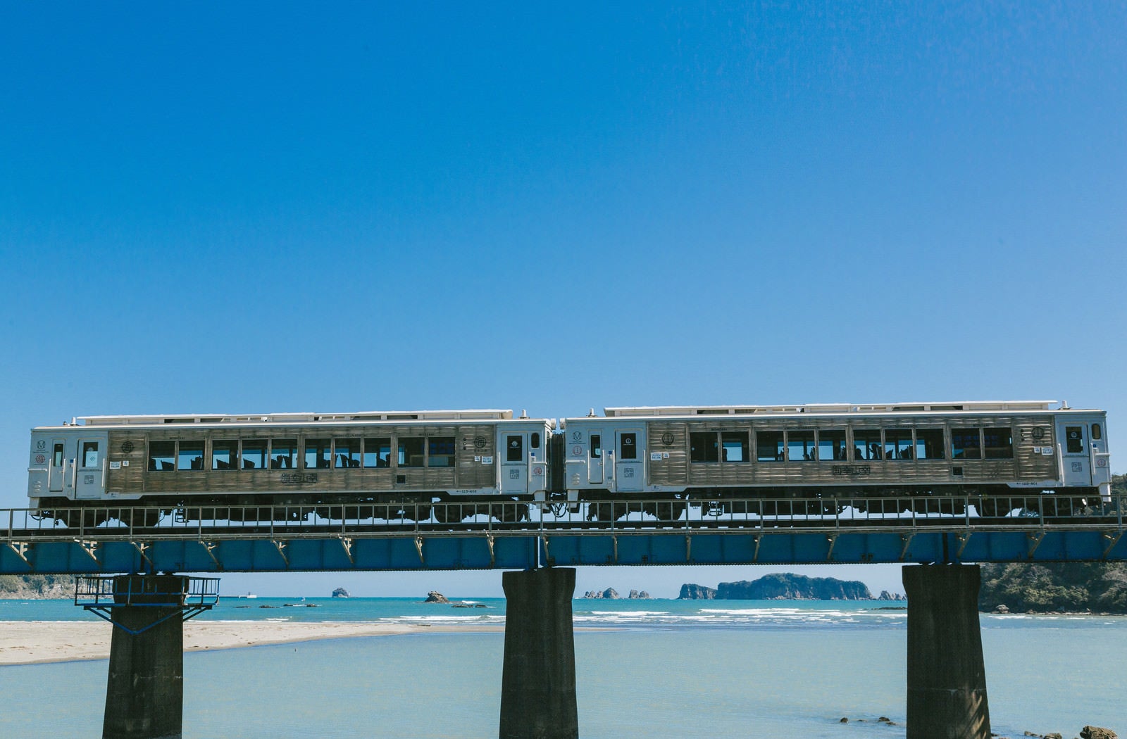 「七ツ八重をバックに走る観光列車「海幸山幸」」の写真