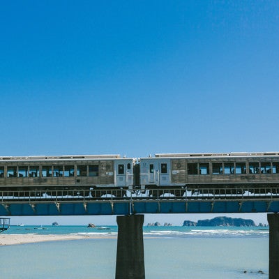 七ツ八重をバックに走る観光列車「海幸山幸」の写真