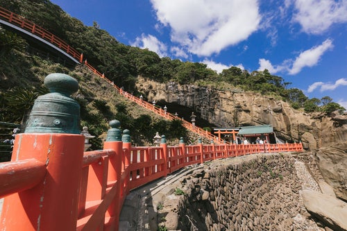 断崖にある鵜戸神宮と朱塗りの柵（玉垣）の写真