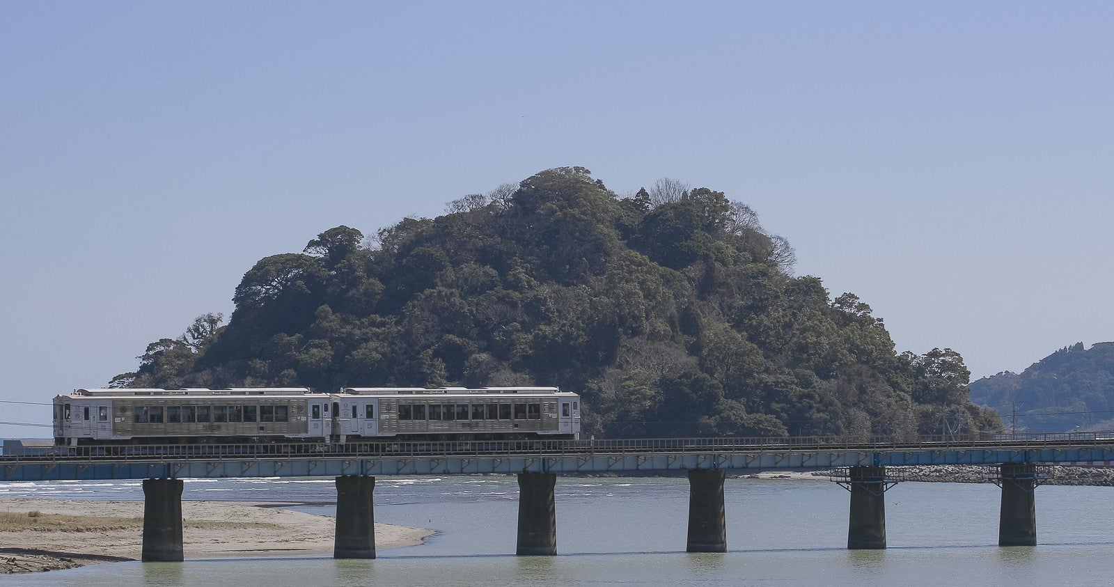 「虚空蔵島をバックに走る観光列車「海幸山幸」」の写真