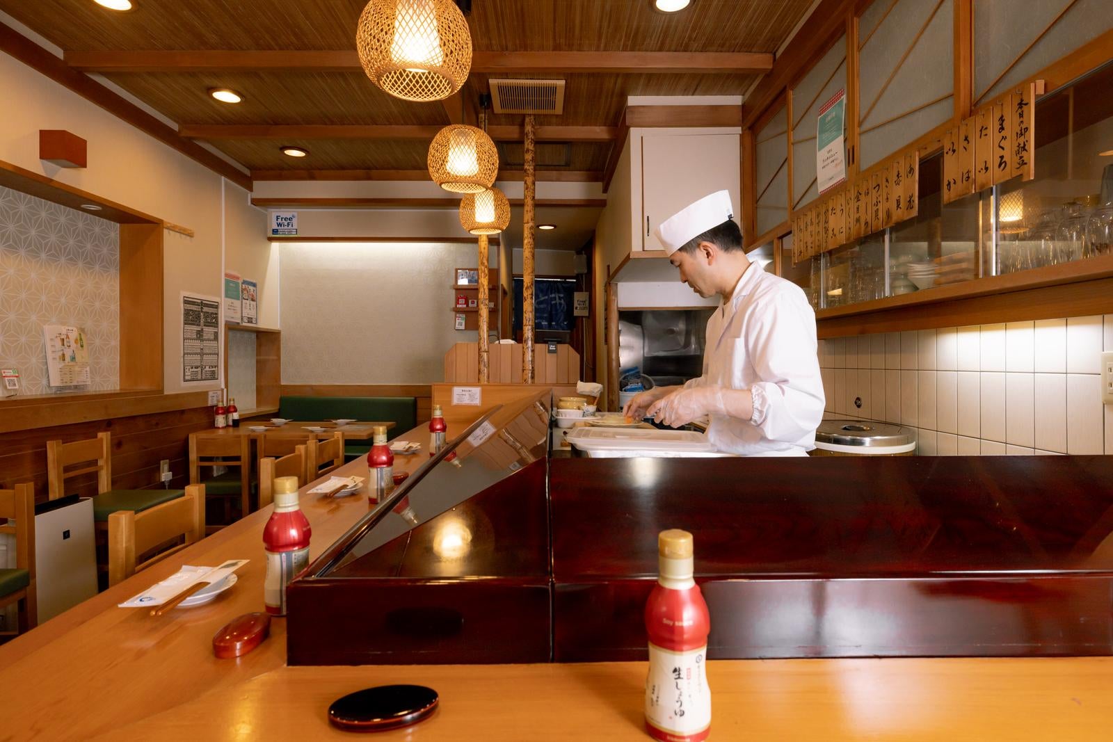 「木目調の店内と寿司職人」の写真