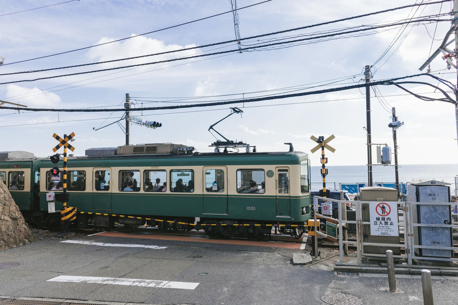 「アニメのワンシーンで登場しそうな鎌倉高校前駅の踏切と江ノ電」の写真