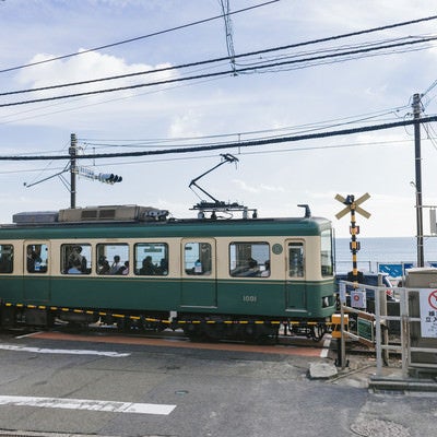 アニメのワンシーンで登場しそうな鎌倉高校前駅の踏切と江ノ電の写真