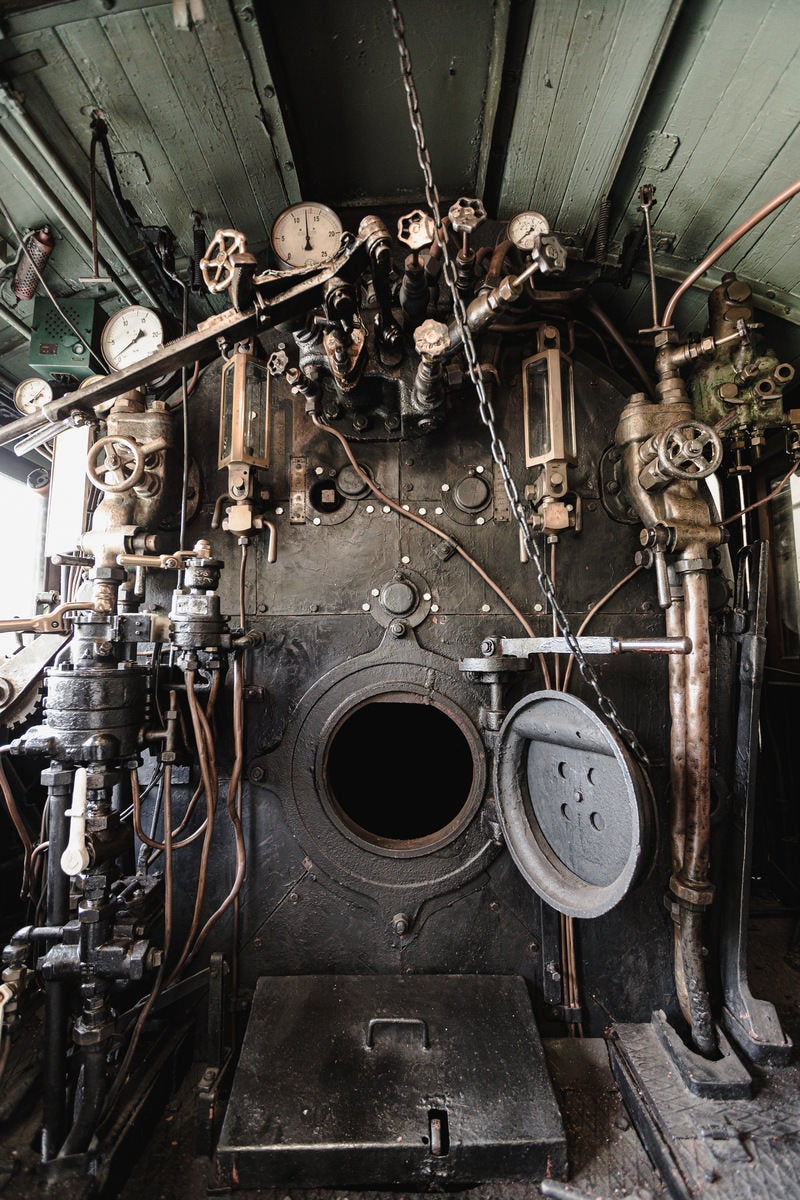 「各種レバーや計器類などがびっしりと並ぶ蒸気機関車・9600形59647号機の機関室内」の写真