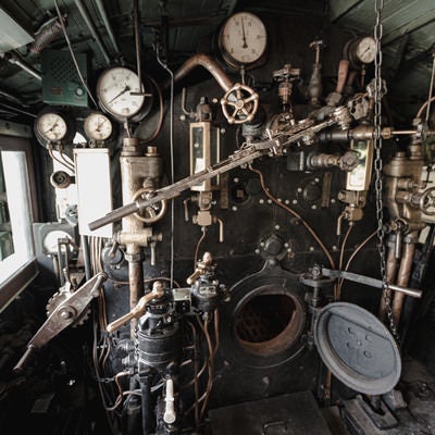 計器類が並ぶ蒸気機関車の機関室内の様子の写真