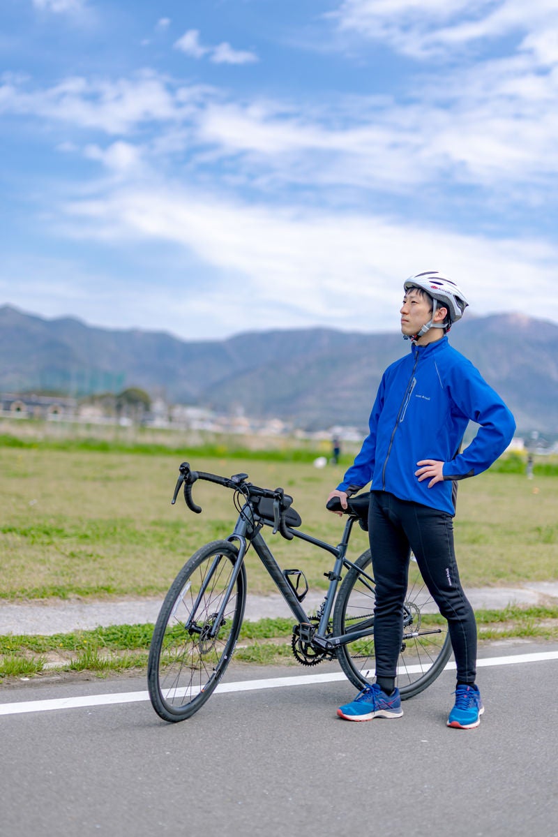 「清々しい青空と福智山系を背にロードバイクを持つ男性」の写真［モデル：モデルリリース］