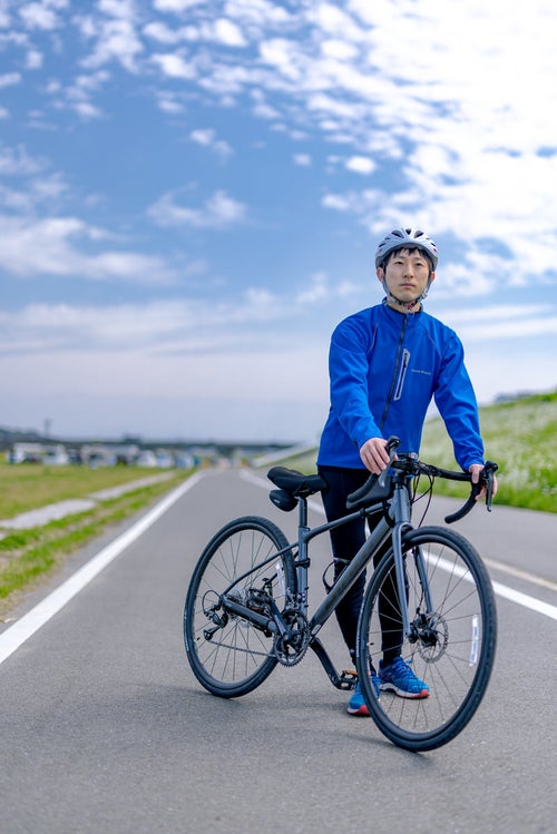 晴れた日にロードバイクで直方北九州自転車道を走り出そうとする男性の写真