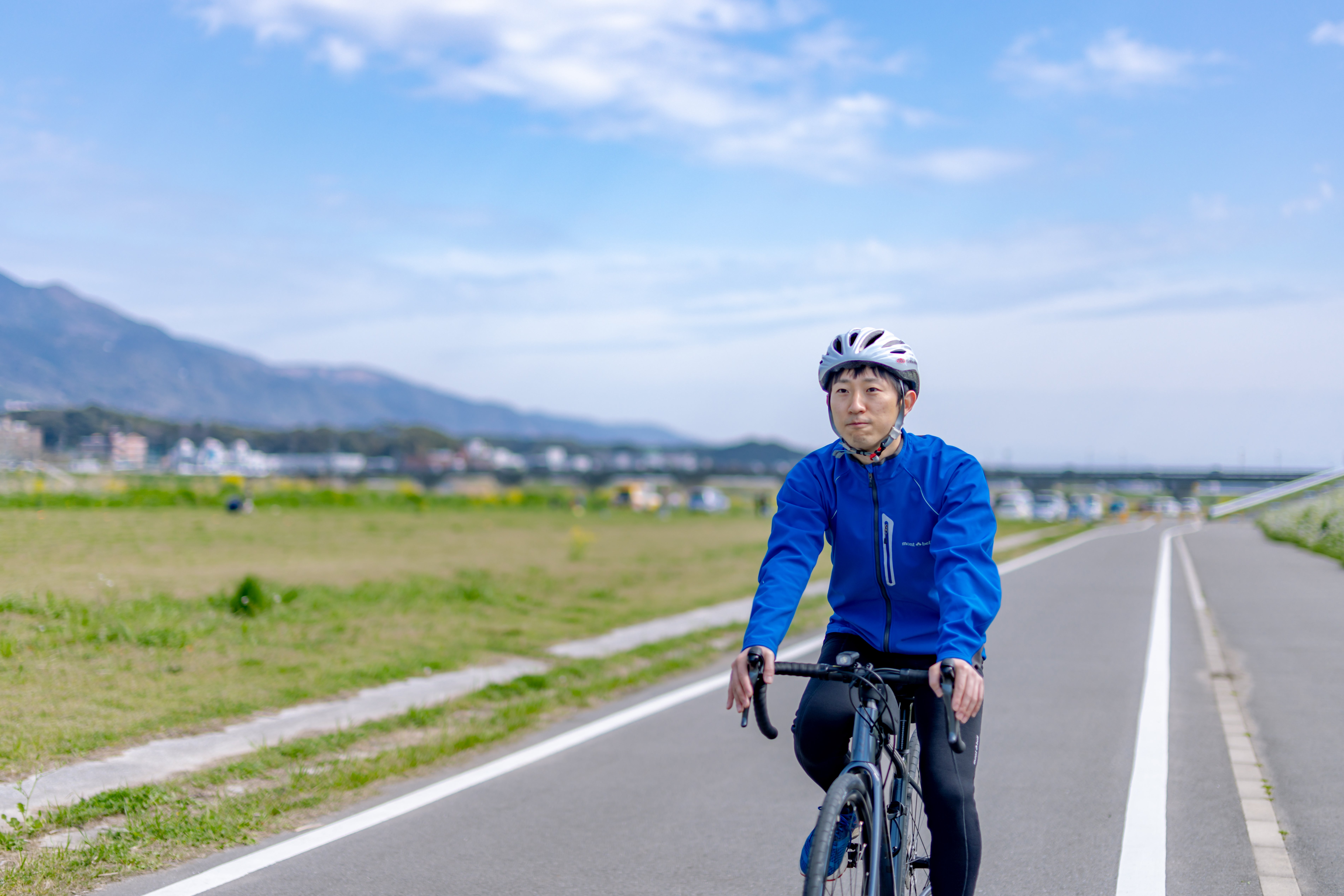 直線コースを走行するロードバイクの男性の写真