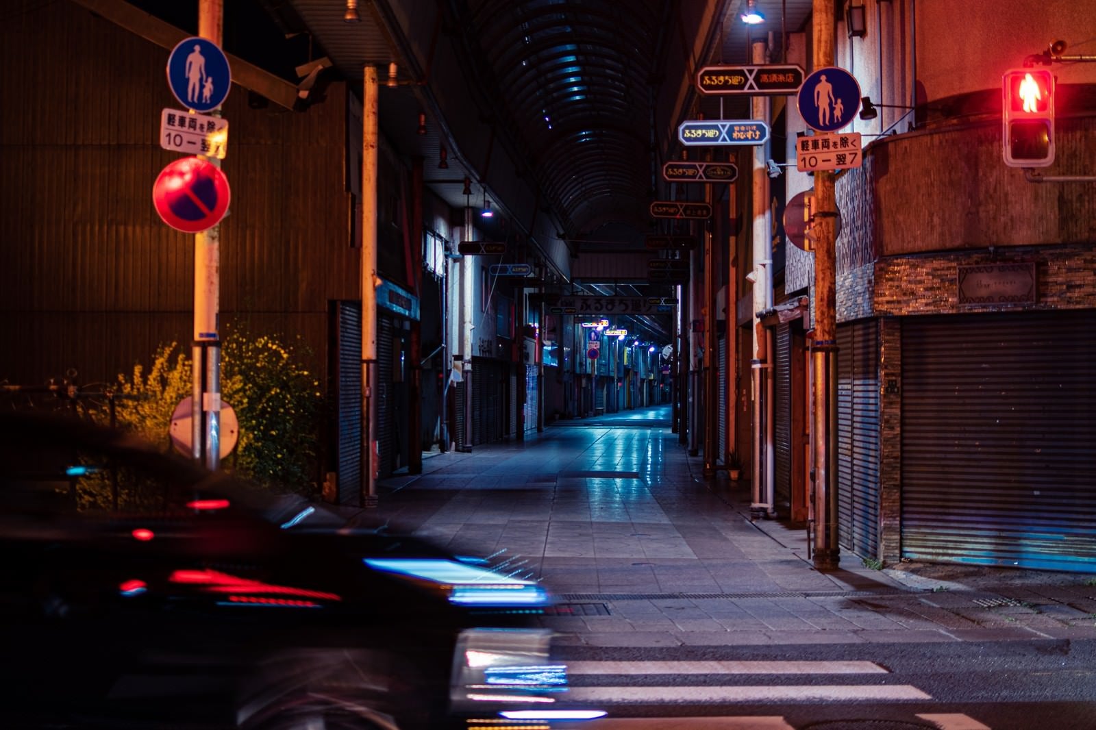「車の往来と深夜の直方市古町商店街」の写真